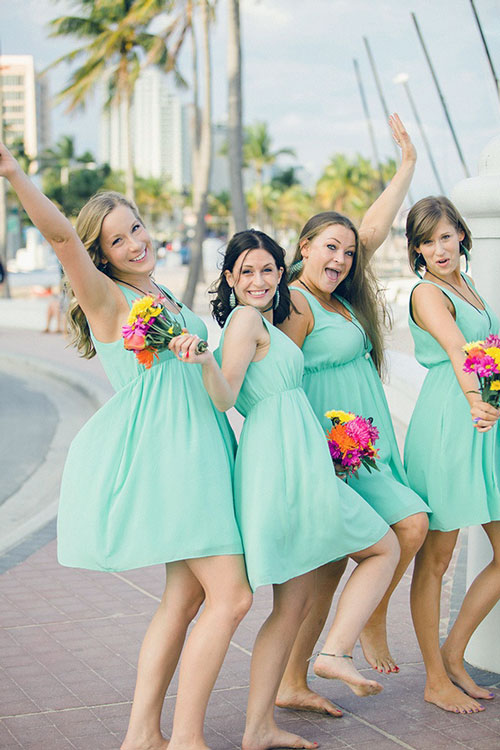 Bridesmaids in strapless tea-length dresses with different floral prints.